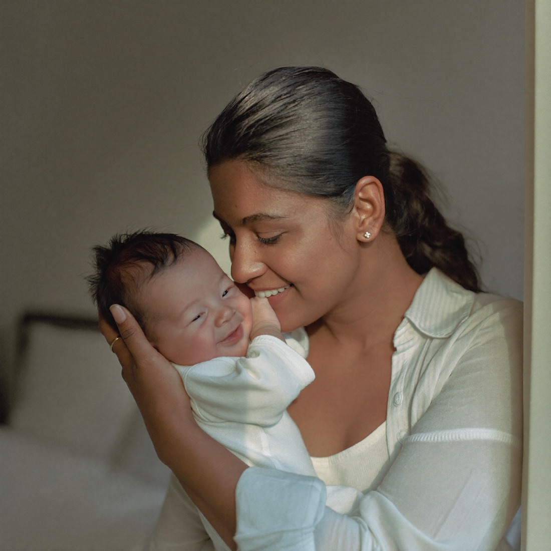 A mother cradling her smiling baby — sample golden moment keepsake